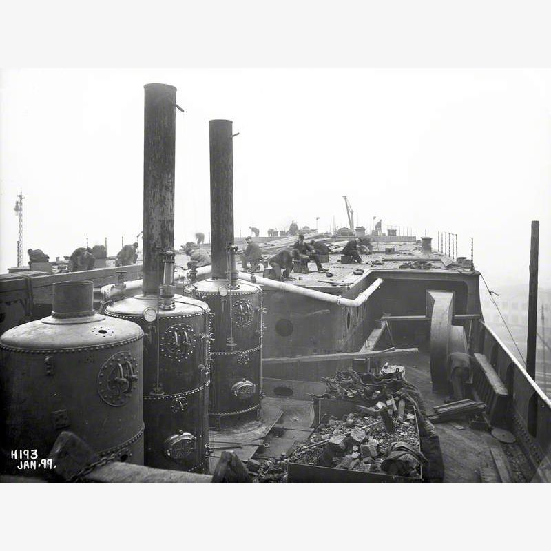 Portable boilers and shipwrights laying deck prior to launch