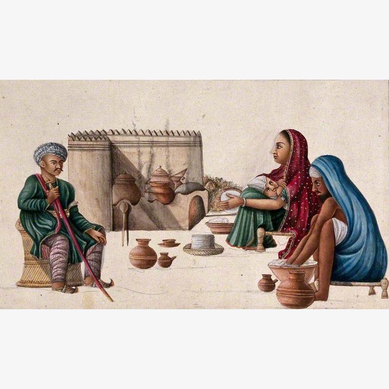 A High Ranking Man Sitting in Front of a Couple Preparing Chappatis (Bread) as the Woman Nurses Her Baby