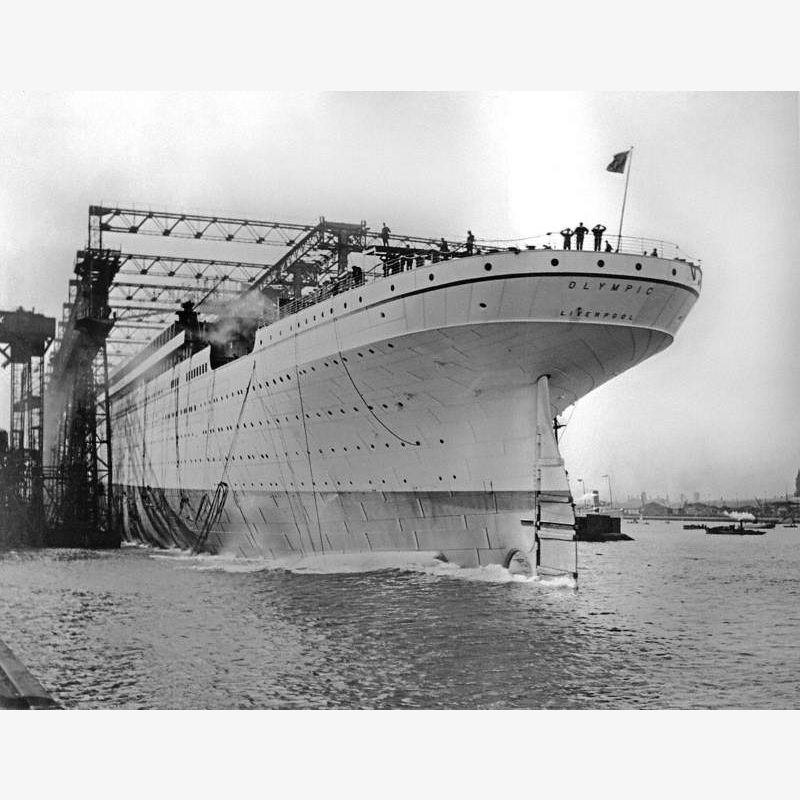 Launch; port stern view of light grey painted hull entering water